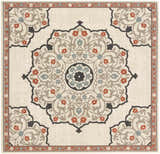 Close-up of the Dolomite Carpet - Clearance. Beige rug with a traditional floral medallion pattern in brown, black, rust, and sage. Design-Square-73