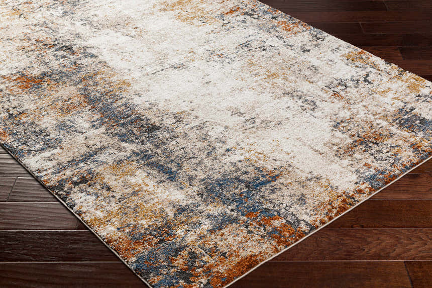 Close-up of Donar Thick Luxe Rug in beachhouse color. Abstract pattern with ivory, blue, tan, and brown tones. Luxe texture. Corner