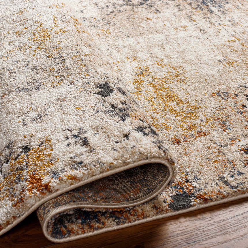 Close-up of the Donar Thick Luxe Rug showing its ivory, tan, and blue abstract pattern and plush texture. Fold