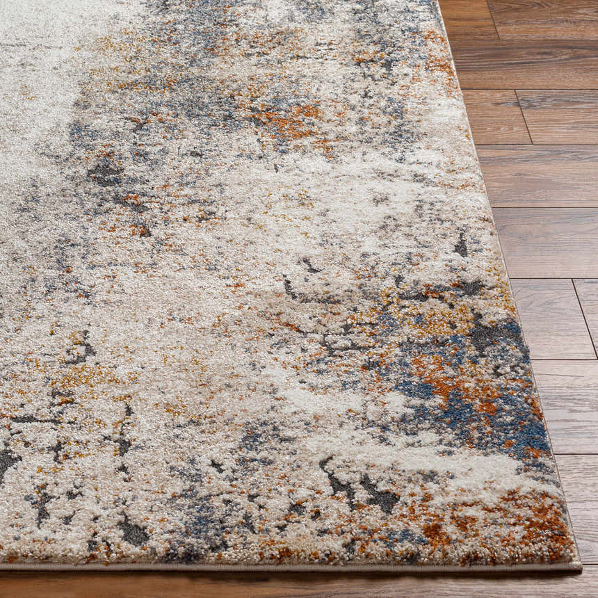 Close-up of the Donar Thick Luxe Rug showing its abstract pattern, ivory, blue, tan, and gray colors, and textured pile. Front
