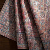 Close-up of the Dormont Washable Area Rug showing the chenille texture and colors of coral, denim, and tan. Fold