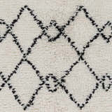 Close-up of the hand woven Dukedom Area Rug. Black geometric shapes on a soft, ivory, wool shag. Swatch