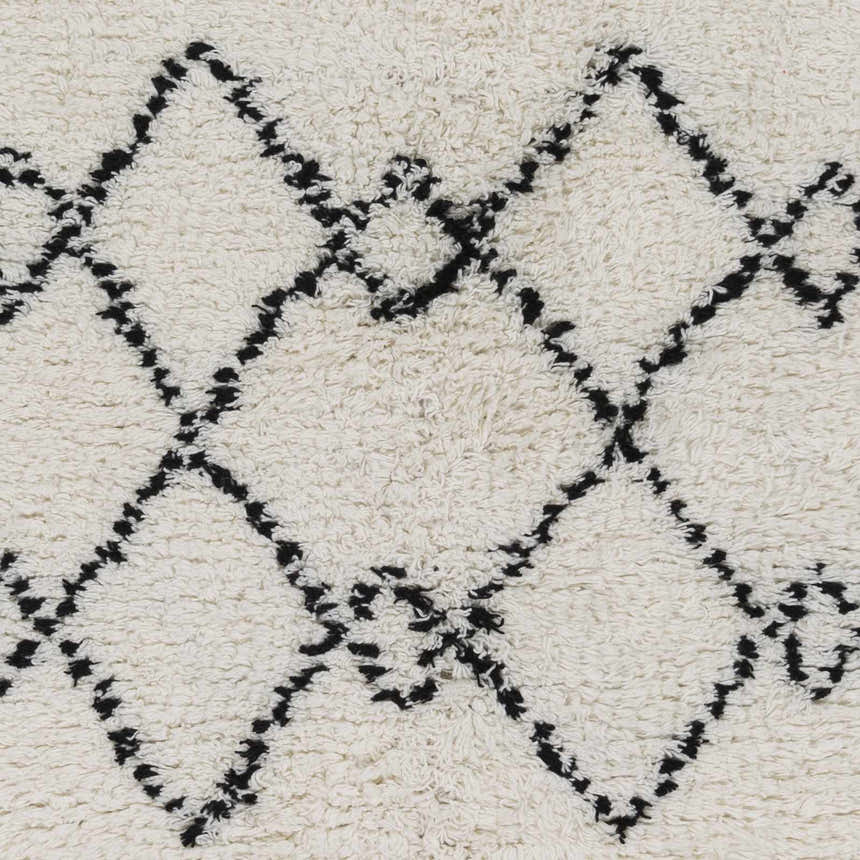Close-up of the hand woven Dukedom Area Rug. Black geometric shapes on a soft, ivory, wool shag. Swatch