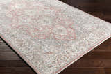 Close-up of the hand-knotted Dunmor Area Rug. Features a traditional Persian pattern in brick red, charcoal, and cream. Corner