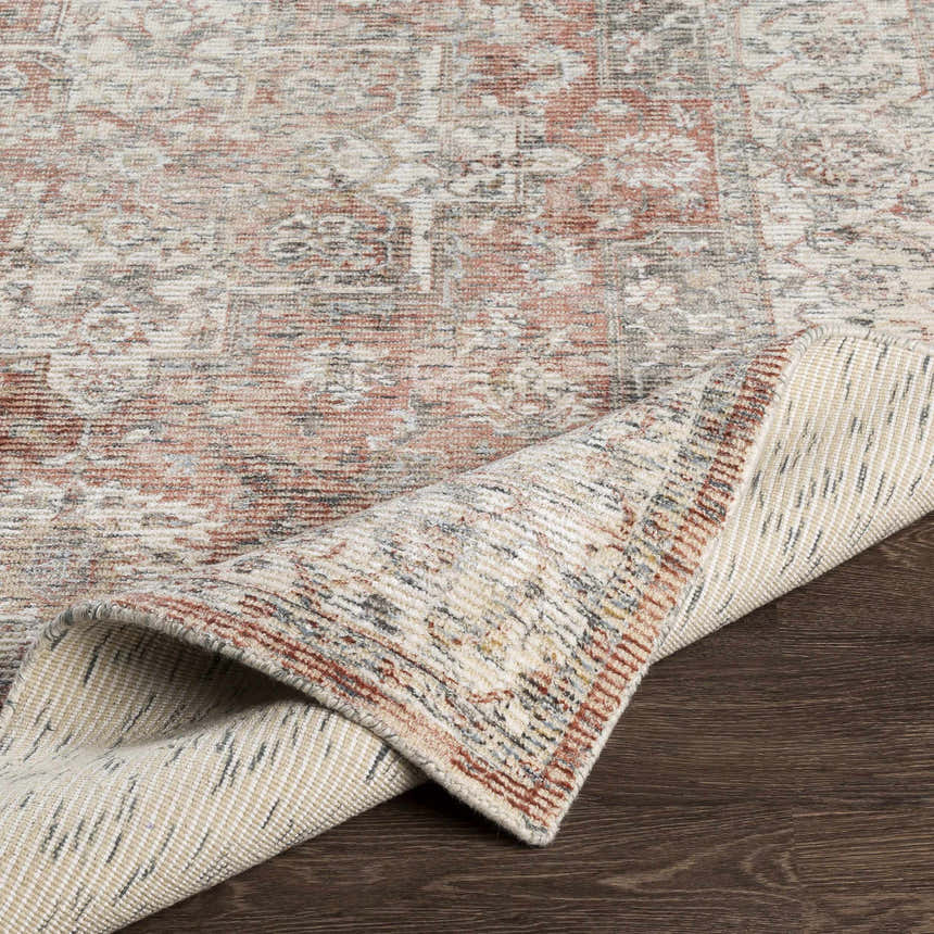Close-up of the hand-knotted Dunmor Area Rug showing brick red, charcoal, and cream colors with a traditional Persian pattern. Fold