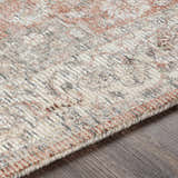 Close-up of the hand-knotted Dunmor Area Rug. Brick red, charcoal, and cream hues in a traditional Persian-inspired pattern. Texture