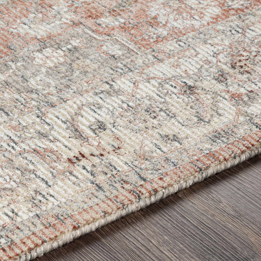 Close-up of the hand-knotted Dunmor Area Rug. Brick red, charcoal, and cream hues in a traditional Persian-inspired pattern. Texture