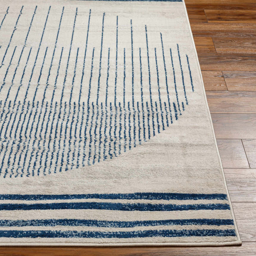 Close-up of the Duri Area Rug showing a geometric pattern in admiral blue and natural gray on a wood floor. Front