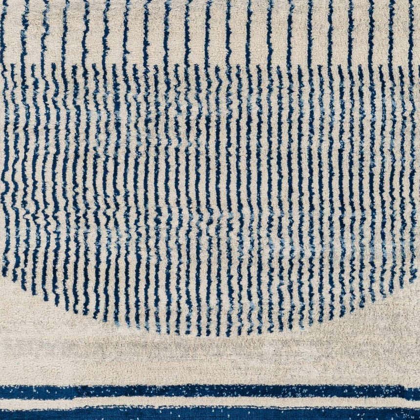 Close-up of the Duri Area Rug, featuring a geometric pattern with admiral blue stripes on a natural gray background. Swatch