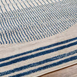 Close up of the Duri Area Rug in admiral blue and natural gray with a geometric striped pattern. Texture