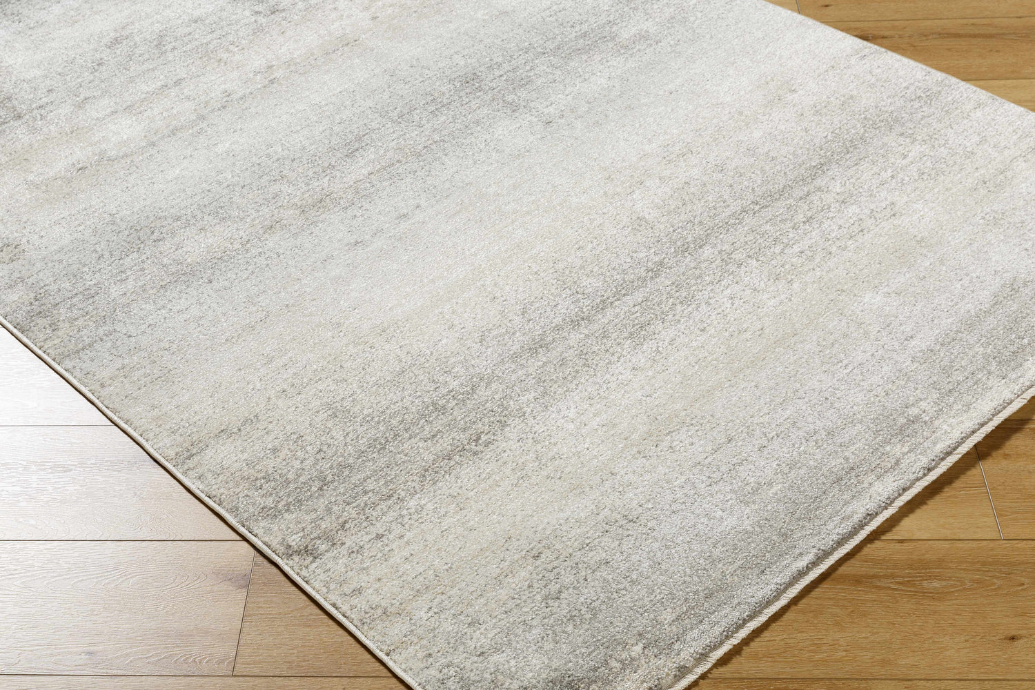 Close-up of the Uzima Gray Area Rug showing its subtle light slate and medium gray contemporary design and soft texture. Corner