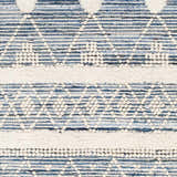 Close-up of the Eben Area Carpet showing a hand-woven blue and off-white geometric pattern and textured details. Swatch