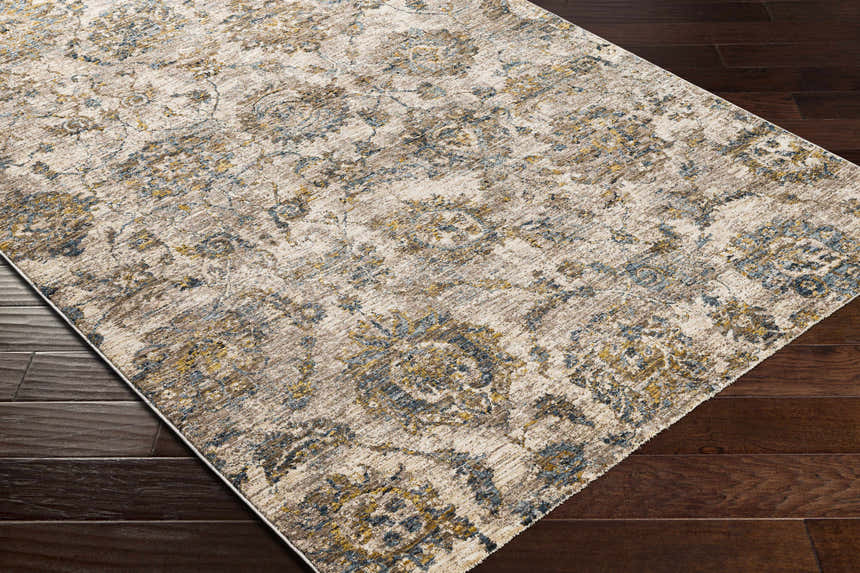 Close-up of the Morinville Teal Floral Rug, showcasing its brown, teal, and mustard floral pattern on dark wood floors. Corner