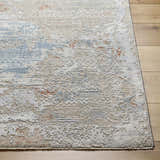 Close-up of the Efren Thick Luxe Area Rug in dark beige, dusty sage, and gray on a light wood floor. Contemporary style. Front
