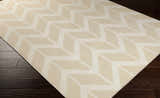 Close-up of the Elamton Area Rug, a hand-woven wool rug with a contemporary geometric pattern in beige and cream. Corner