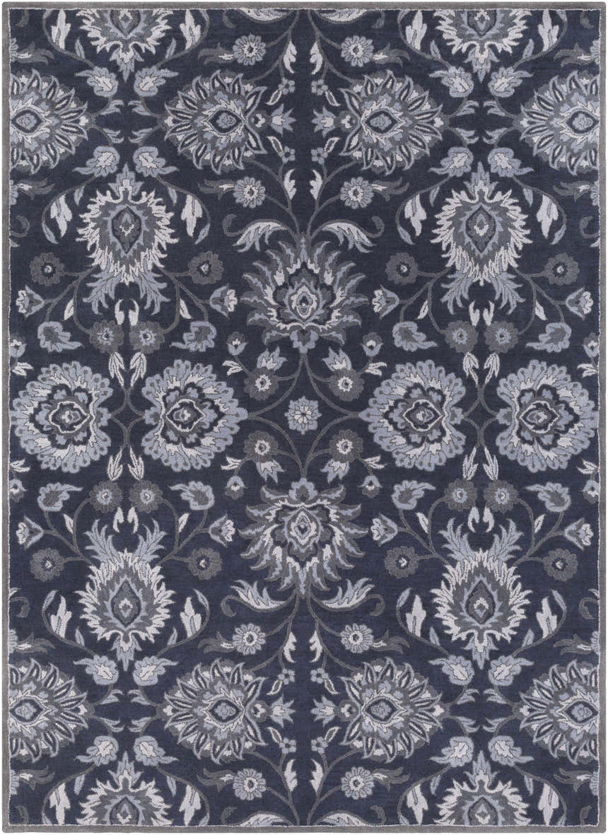 Close-up of the Conesus Hand Tufted Blue Area Rug, featuring a traditional floral pattern in denim, slate, and charcoal hues. Design-Rectangle-811
