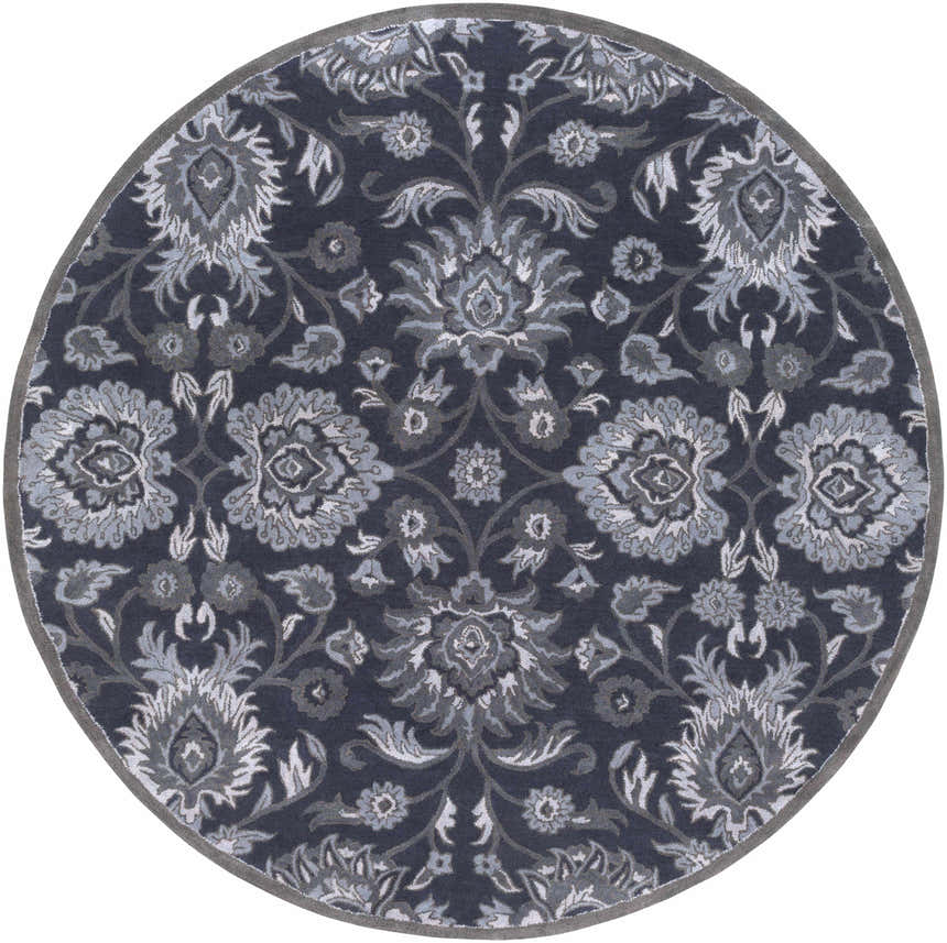 Close-up of the round Conesus Hand Tufted Blue rug. Features a traditional floral pattern in charcoal, denim, and slate blue wool. Design-Round-8