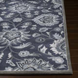 Close-up of the Conesus Hand Tufted Blue Area Rug showing its floral pattern and charcoal, denim, and slate blue colors. Front