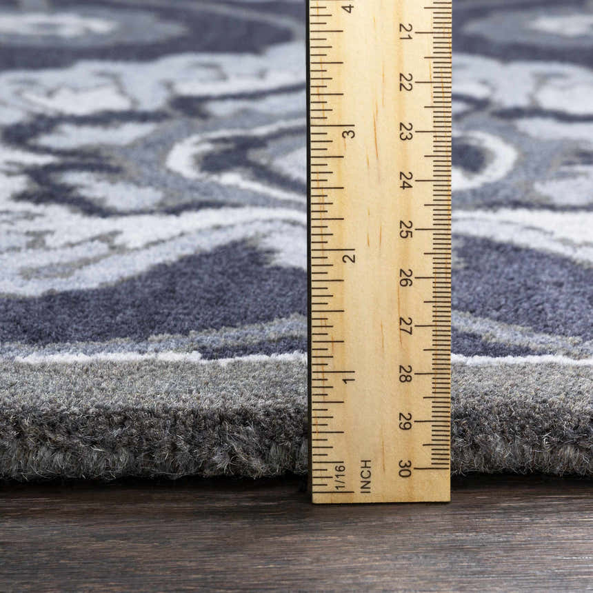 Close-up of the Conesus Hand Tufted Blue Area Rug showing wool texture, pile height, and charcoal, denim, and slate blue colors. Pile