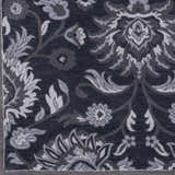 Close-up of the Conesus Hand Tufted Blue 1191 Area Rug. Features a traditional floral pattern in denim, charcoal, and slate blue. Swatch