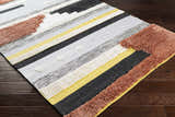 Close-up of the Elsenham Area Rug showing its black, cream, mustard, and rust stripes and textured details. Corner