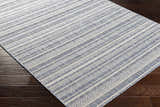 Close-up of Emirgazi Striped Nordic Rug with blue and off-white stripes on dark wood floor. Bohemian style. Corner