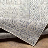 Close-up of the Epson Indoor & Outdoor Rug. Bohemian style rug with blue and gray geometric patterns. Machine woven polypropylene. Fold
