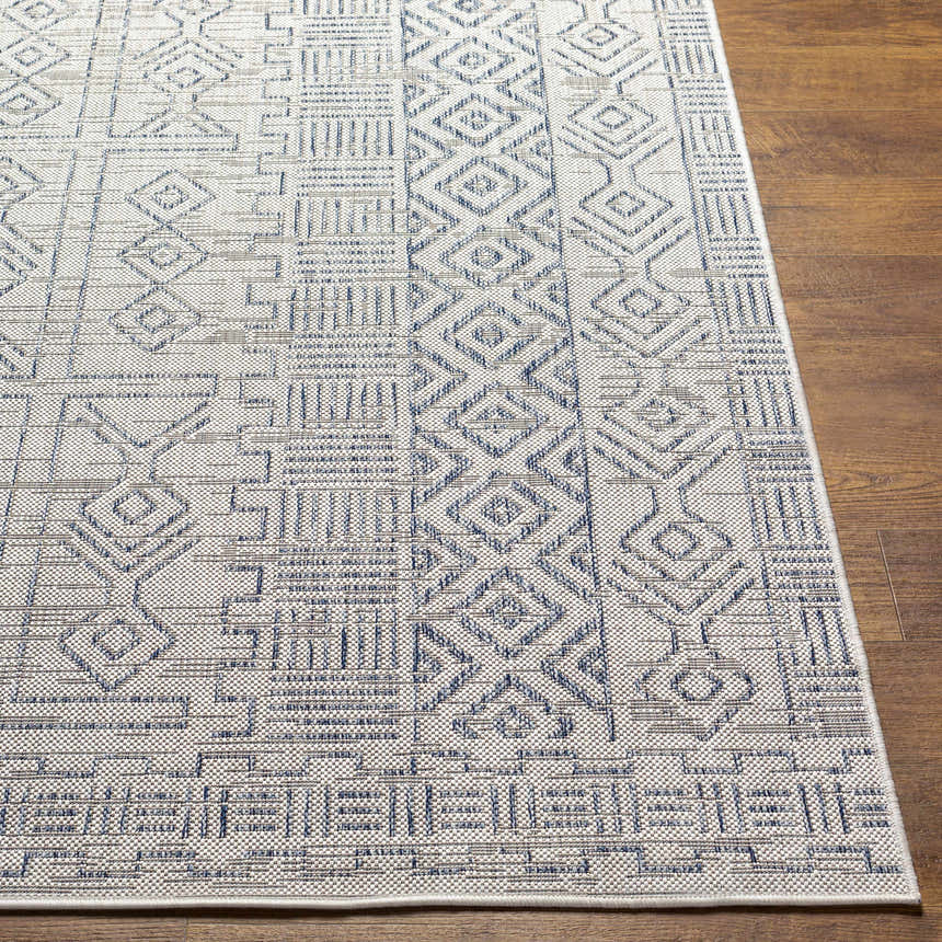 Close-up of Epson Indoor Outdoor Rug in blue, gray, and off-white with a geometric, bohemian-inspired design. Front
