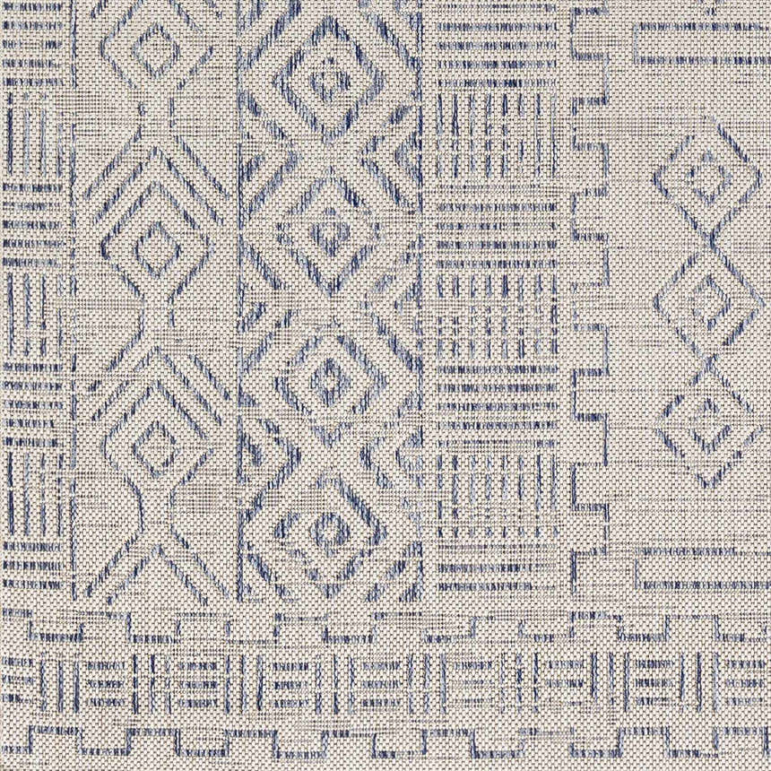 Close-up of Epson Indoor & Outdoor Rug. Bohemian style rug with blue geometric pattern on oatmeal background. Swatch