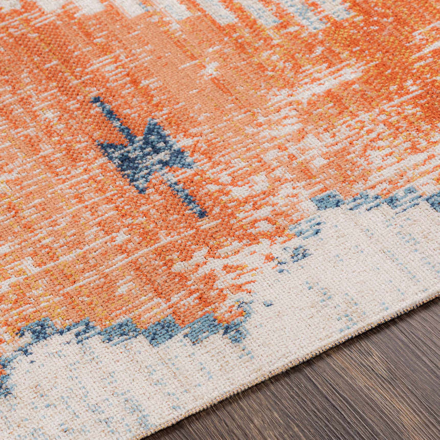 Close-up of the Etobicoke Area Rug showing brick red, cream, and denim hues in a Southwestern-inspired pattern. Texture