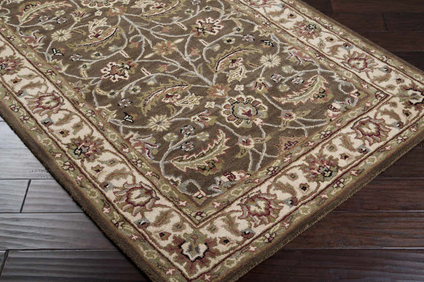 Close-up of the Eupora Wool Rug featuring a traditional floral pattern in shades of brown, red, green, and ivory. Corner