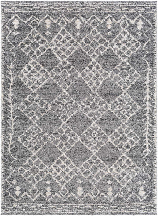 Close-up of the Fadden Area Rug, a machine-woven rug with a gray, charcoal, and off-white geometric diamond pattern. Design-Rectangle-5373
