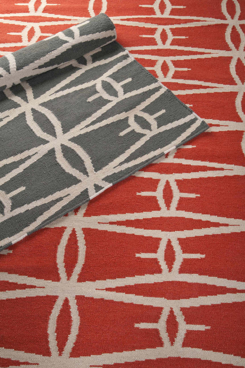 Close-up of the hand-woven Lipan Area Rug. Charcoal and peach wool rug with a contemporary geometric pattern. Styleshot
