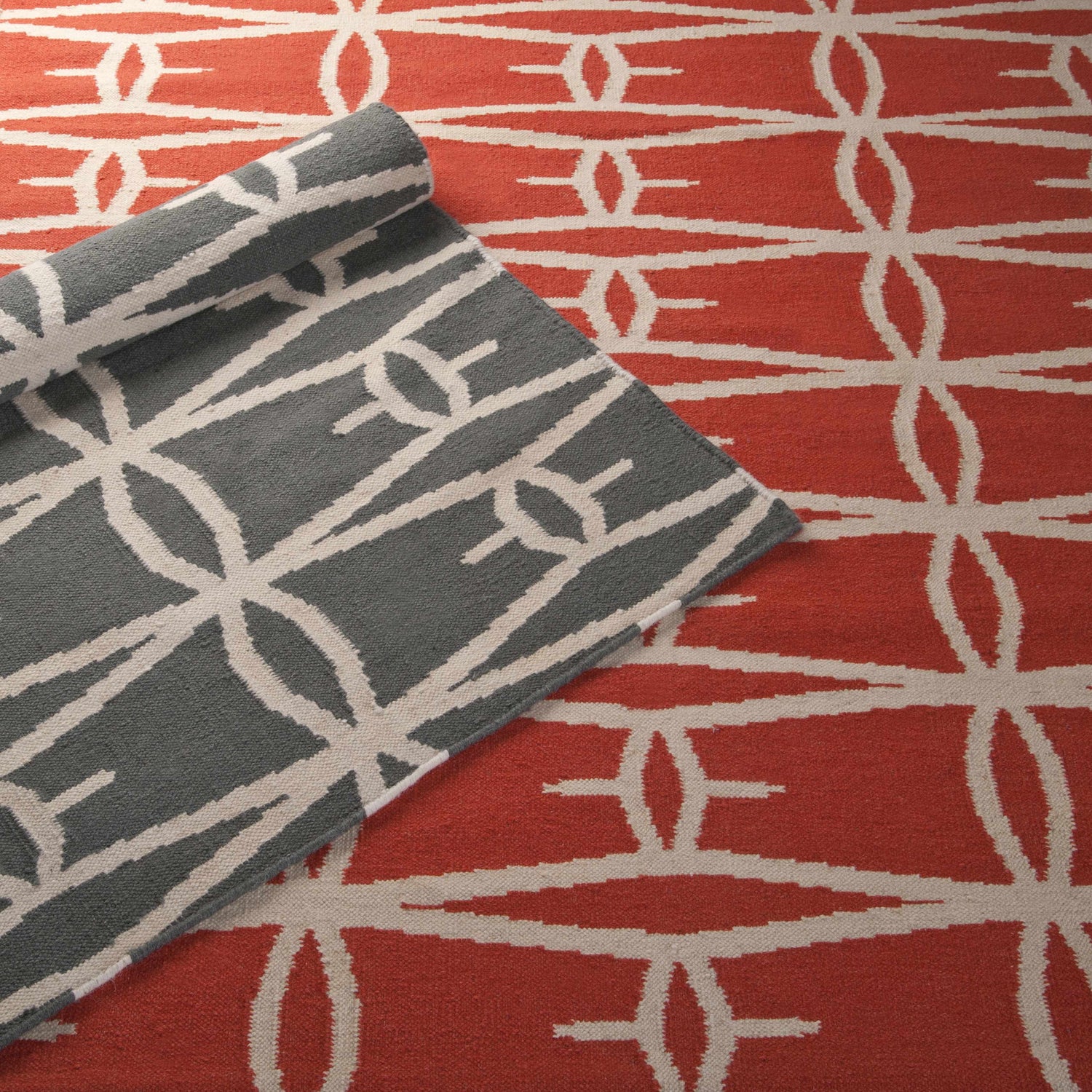 Close-up of the Lipan Area Rug in charcoal and peach, showcasing its hand-woven, geometric design. Styleshot
