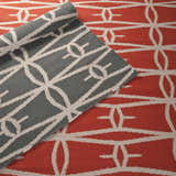 Close-up of the Lipan Area Rug, a hand-woven wool rug in charcoal and peach with a geometric pattern. Contemporary style. Styleshot