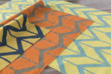 Close-up of the Eland Area Carpet showing its geometric pattern in dark blue, olive, and orange wool. Styleshot