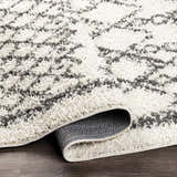 Close up of the charcoal and cream Fenstanton Area Rug, a shag rug with a contemporary geometric pattern. Fold