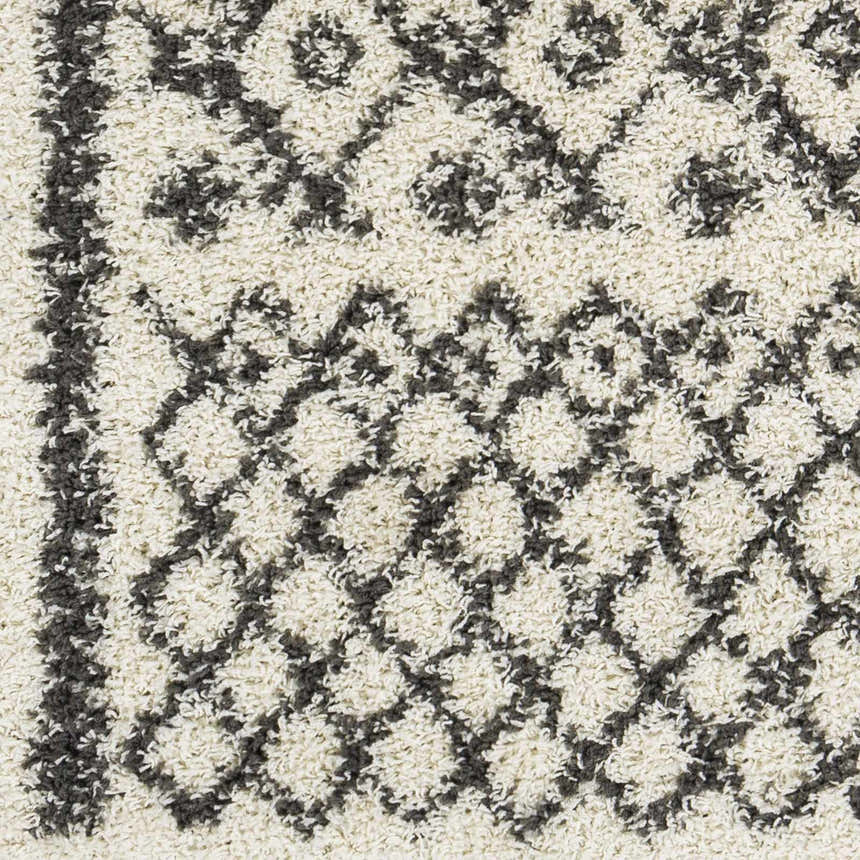 Close-up of the Fenstanton Area Rug; charcoal and cream shag rug with a geometric diamond pattern and soft texture. Swatch
