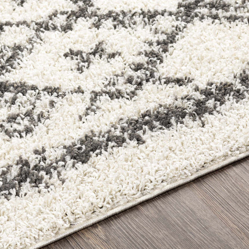Close-up of the plush Fenstanton Area Rug. Charcoal and cream shag rug with a modern geometric pattern. Texture