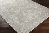 Close-up of Fernwood Area Rug with gray floral medallion pattern on a light gray background. Corner