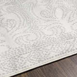 Close-up of Fernwood Area Rug showing gray dotted paisley pattern on a light gray, machine-woven polypropylene rug. Texture