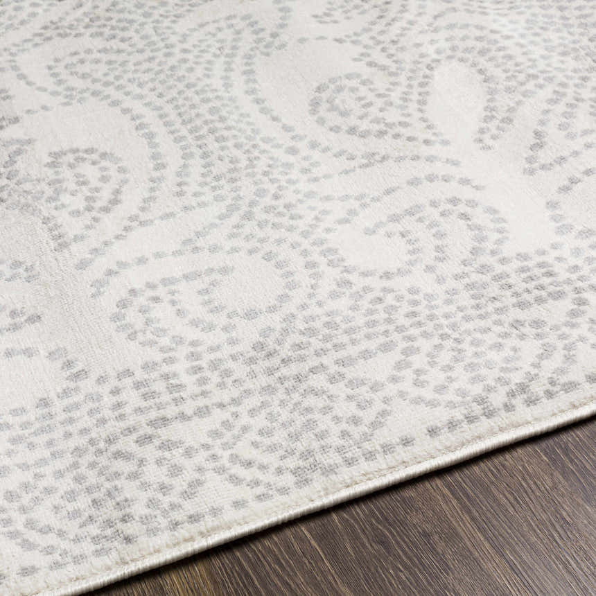 Close-up of Fernwood Area Rug showing gray dotted paisley pattern on a light gray, machine-woven polypropylene rug. Texture