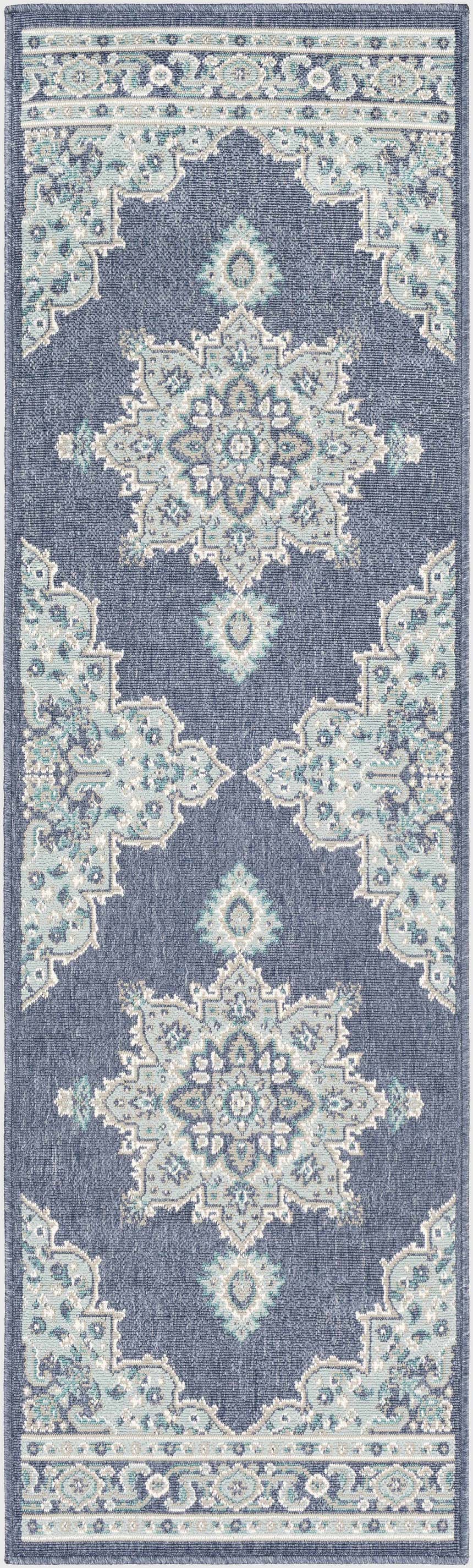 Close-up of the Ferron Area Rug. Navy olefin rug with pale blue, taupe, teal, and white traditional-style medallion pattern. Design-Runner-2379