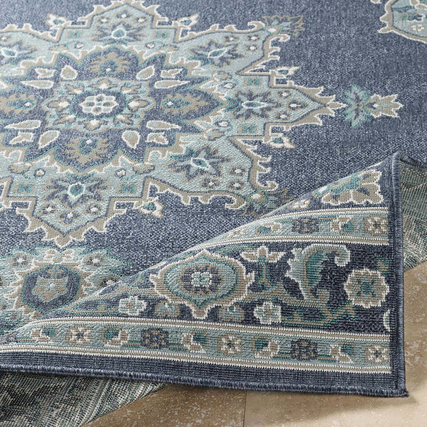 Close-up of the Ferron Area Rug, showing a traditional oriental pattern in navy, pale blue, taupe, teal, and white. Fold