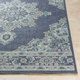 Close up of the Ferron Area Rug showing a navy, teal, and taupe traditional pattern. Front
