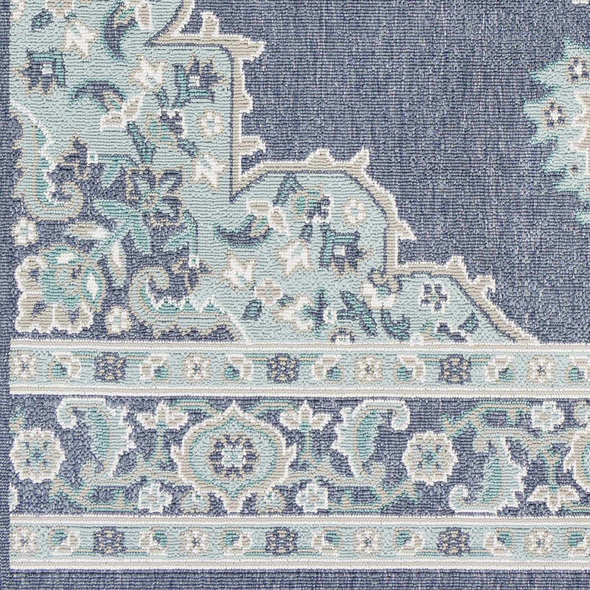 Close up of the Ferron Area Rug showing a navy, teal, and taupe floral and geometric pattern. Swatch