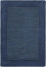 Close-up of a Bordered Solid Ink Blue Wool Rug showing the textured wool and color variations. Design-Rectangle-23