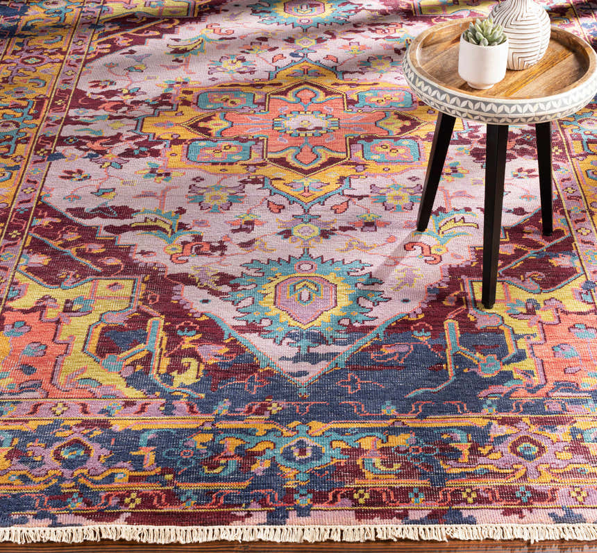 Close-up of the Flagtown Area Rug, a hand-knotted wool rug with blue, coral, and mustard tones in a traditional Oriental pattern. Styleshot