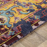 Close-up of the hand-knotted Flagtown Area Rug. Features a traditional, colorful pattern in blue, burgundy, and mustard hues. Pile