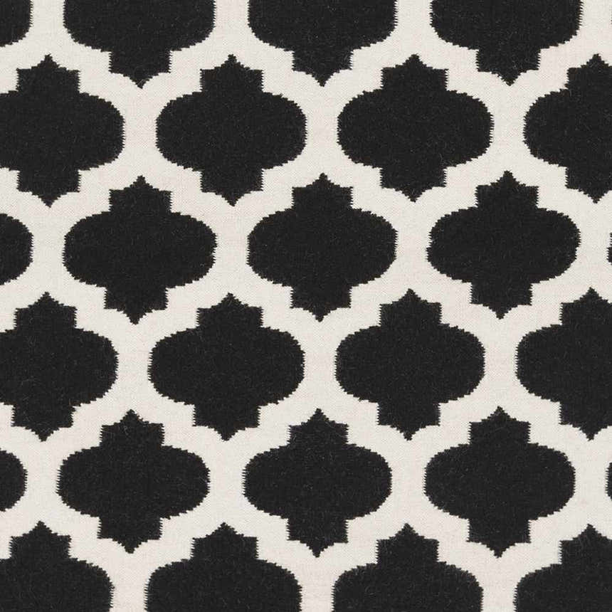 Close-up of the Fleetville Area Rug's black and ivory geometric pattern. Hand-woven wool texture. Swatch